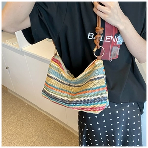 Close-up of rainbow striped woven tote bag featuring rustic knot shoulder straps
