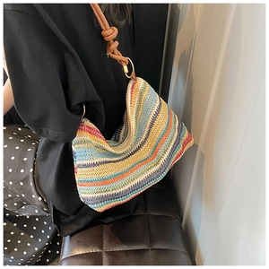 Detail of colorful striped woven tote bag with brown leather knotted shoulder strap