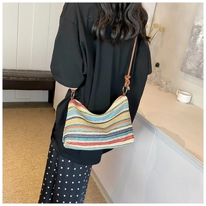 Detail of colorful rainbow striped woven tote bag with brown leather shoulder strap