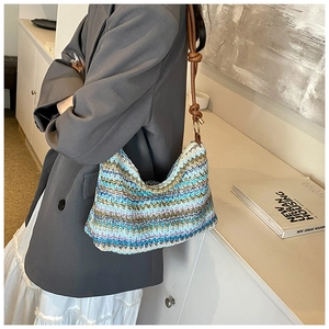 Close-up of rainbow striped knit tote bag with brown leather knotted shoulder strap