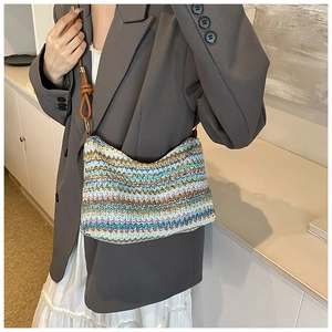 Detail of colorful zigzag knit hobo bag with brown leather strap and gold ring hardware