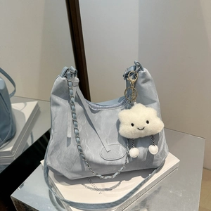Light blue nylon shoulder bag with silver chain, plush cloud charm, and wide strap