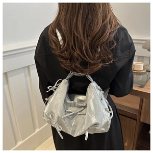 Silver metallic backpack for women featuring stylish bow details and a ruched leather texture