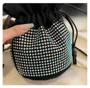 Close-up of a black drawstring bucket bag covered in iridescent colorful rhinestones