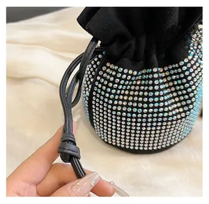 Detail of the drawstring closure and sparkling rhinestones on the suede bucket bag