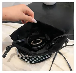 Detail view of the rhinestone bucket bag showing the black fabric lining and inner pocket