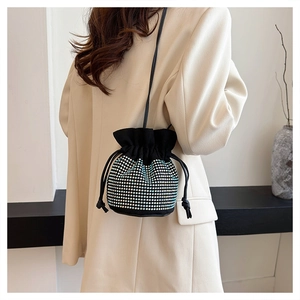 Close-up of sparkling rhinestone bucket bag with drawstring closure and chain strap