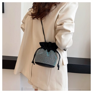 Detail of elegant black bucket bag with sparkling rhinestones and drawstring closure