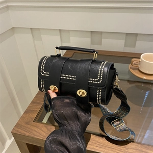 Chic black faux leather handbag with white embroidery and patterned wide strap