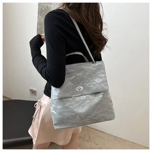 Silver wrinkled texture tote bag worn over the shoulder showing modern metallic finish