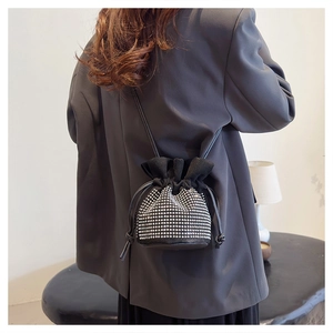 Detail of black drawstring bucket bag with silver rhinestones on a female model