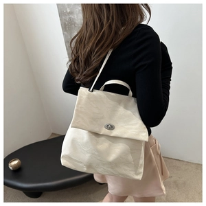 Detail of cream-white backpack with unique wrinkled texture and silver twist lock