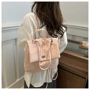 Detail view of pink multi-functional backpack with silver twist lock and minimalist design