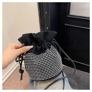 Macro shot of black suede bucket bag featuring silver rhinestones and drawstring closure