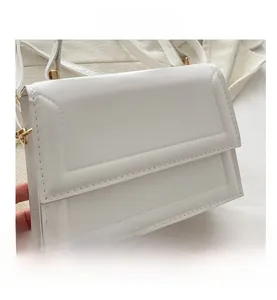 Detail of white leather small square bag with rectangular stitching and gold metal clasp