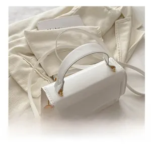 Detail of comfortable fixed handle and golden metal buckles on white crossbody bag