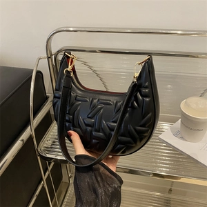 Fashionable black crescent shoulder bag with geometric embossed texture and gold hardware