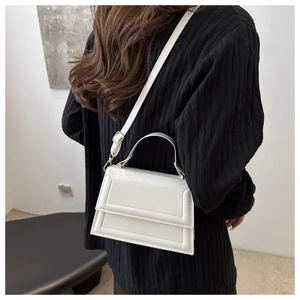 White structured square handbag with layered flap detail shown on a model