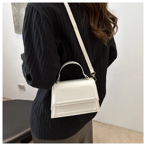 White minimalist square crossbody bag with geometric texture worn by a model