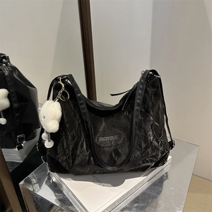 Large black pleated faux leather backpack for women with a cute white teddy bear charm