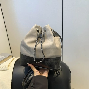 Chic grey canvas and black leather bucket bag with metal chain drawstring and straps