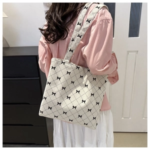 Détail du sac cabas en velours côtelé avec motifs de nœuds noirs et surpiqûres losanges