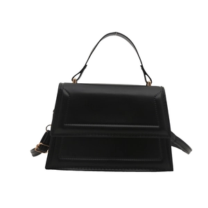 Minimalist black trapezoid handbag with embossed flap and gold-tone hardware for women