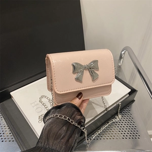 Pink mini crossbody bag with silver bow accent and sleek chain strap for women