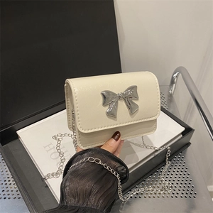 Elegant cream chain crossbody bag with silver bow accent on a stylish background