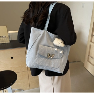 Detail of light blue pleated tote bag with silver butterfly buckle and cloud charm