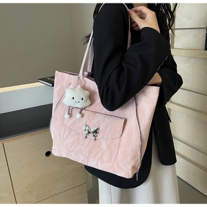 Detail of pink large-capacity tote bag with silver butterfly clasp and plush cloud charm