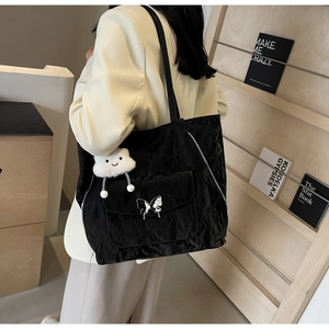 Black tote backpack with crinkle texture and butterfly buckle shown in use