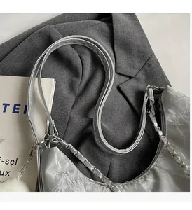 Detail of silver metallic hobo bag with pleated texture and stylish metal chain strap