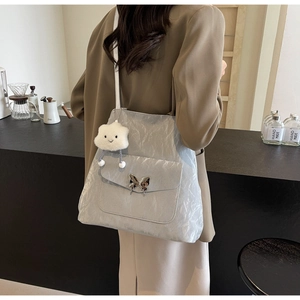 Detail of silver crinkled tote bag with butterfly buckle and cloud plush charm