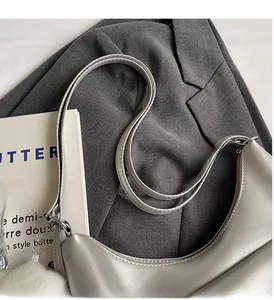 Dettaglio della borsa in pelle PU grigio argento con cerniere in metallo e finiture