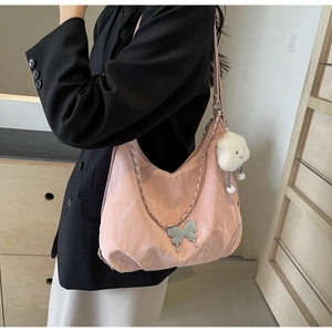 Detailed side view of pink quilted tote bag with silver chain and plush cloud charm