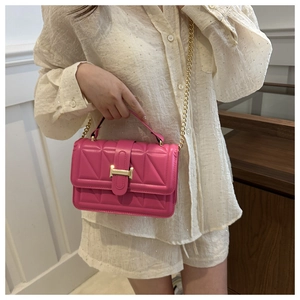 Detailed view of quilted rose pink leather handbag with gold H buckle and chain strap