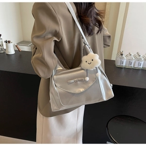 Borsa tote argento metallizzato con fiocco e ciondolo di peluche su modella al caffè