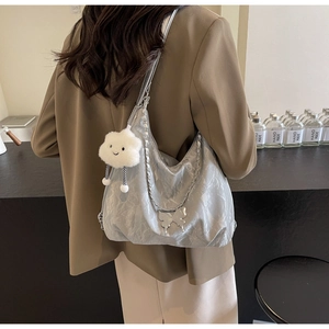 Detail of silver metallic tote bag with chain strap and soft cloud charm decoration
