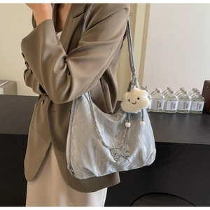 Detail of silver pleated tote bag with cloud charm and butterfly chain decoration