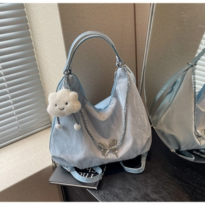 Detail of light blue pleated shoulder bag with silver butterfly chain and cloud charm