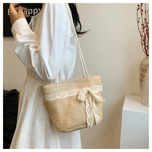 Close-up of woven tote bag featuring delicate white lace trim and bow knot details