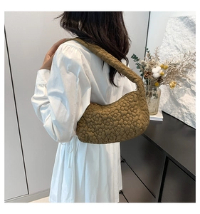 Détail du sac hobo vert olive avec texture florale matelassée 3D porté par un mannequin