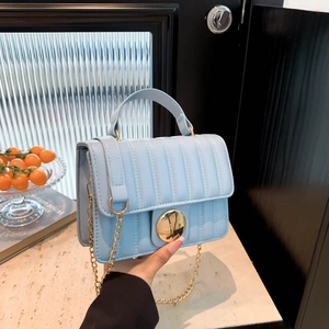 Sac à bandoulière matelassé bleu clair avec fermoir doré sur fond de marbre chic