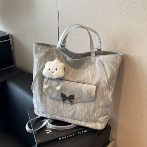 Metallic silver high-capacity tote bag with butterfly buckle and cloud charm accessory