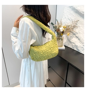Détail du matelassage floral 3D et forme de croissant du sac baguette vert clair