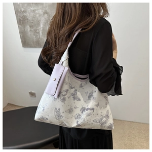 Détail du sac cabas à imprimé papillon avec une petite pochette violette amovible