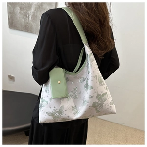 Détail d'un cabas blanc en PU avec imprimé papillon vert et petite pochette assortie