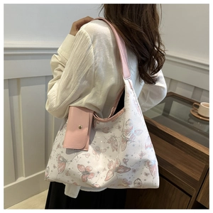 Détail du sac cabas imprimé papillon avec petite pochette rose sur la bandoulière large