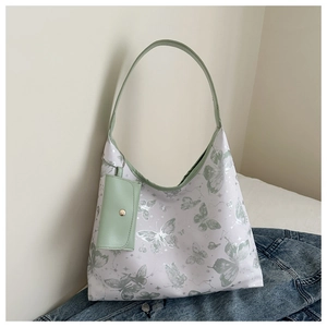 Détail du sac cabas à motif papillon avec mini pochette amovible et bordure en cuir vert